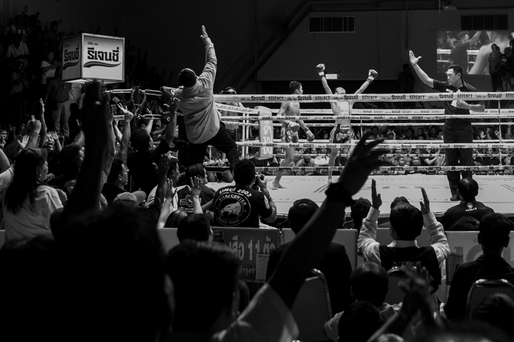 Spectators celebrate the victory of a fighter during his Muay thai bout at Chang 7